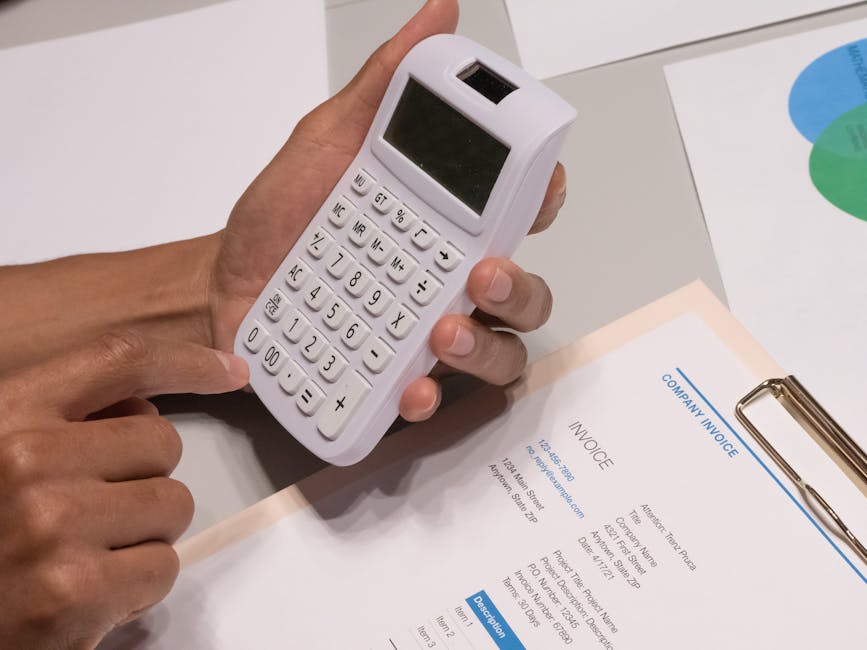 Stack of supplier invoices next to a laptop
